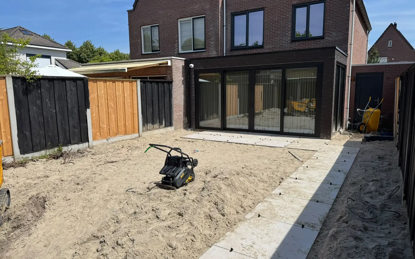 De tuin tijdens het grondwerk, met de woning op de achtergrond