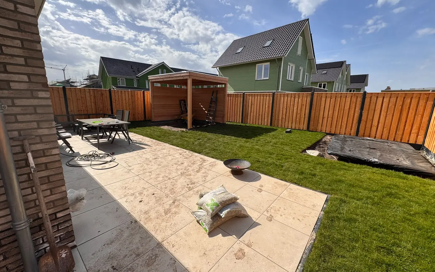 Het aangelegde terras en gazon voor de overkapping
