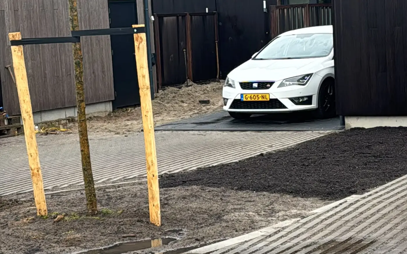 De bestrating loopt door tot aan de parkeerplaats naast de woning