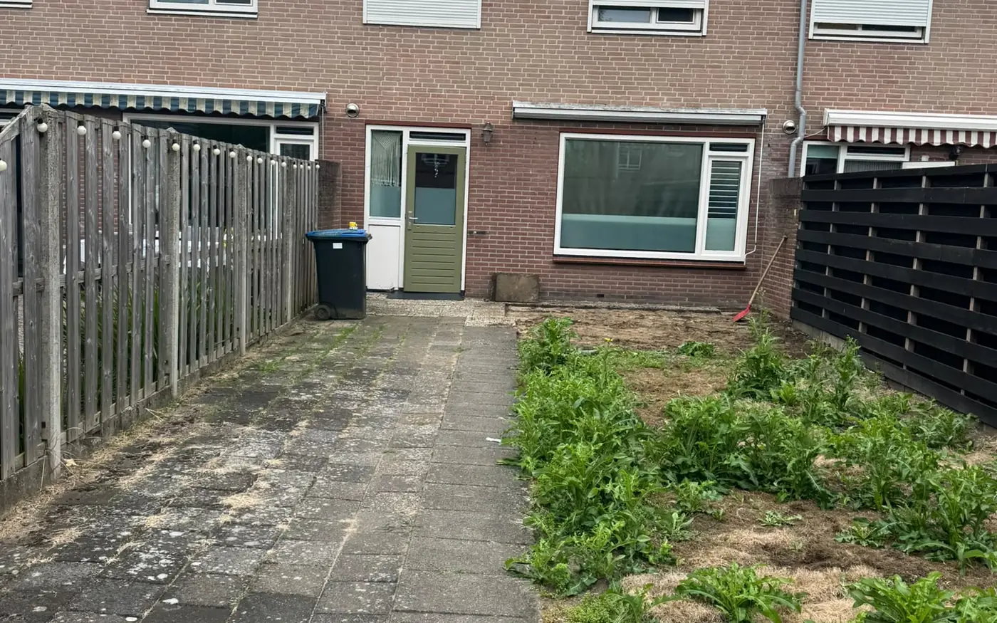 De oorspronkelijke situatie: een dichtgegroeide tuin met oude tegels