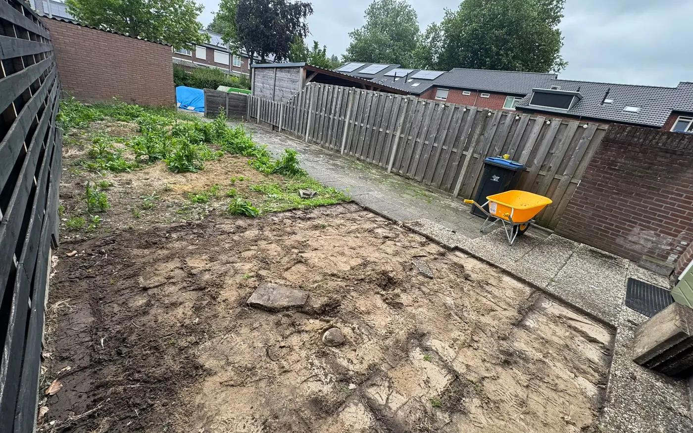 De tuin tijdens het leeghalen, met kruiwagen en losgehaalde grond
