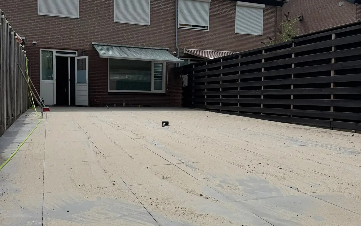 Het bouwrijpe vlak met de woning en de nieuwe schutting