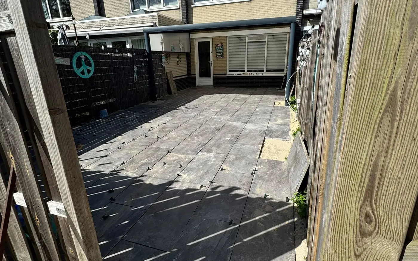 Het terras gezien vanaf de zijkant, langs de houten schutting