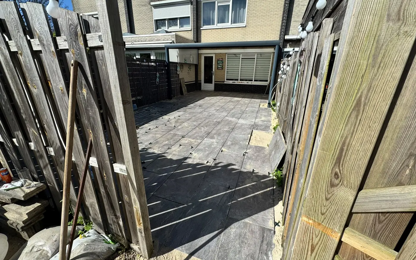 Detail van de doorlopende tegelvloer tot onder de veranda
